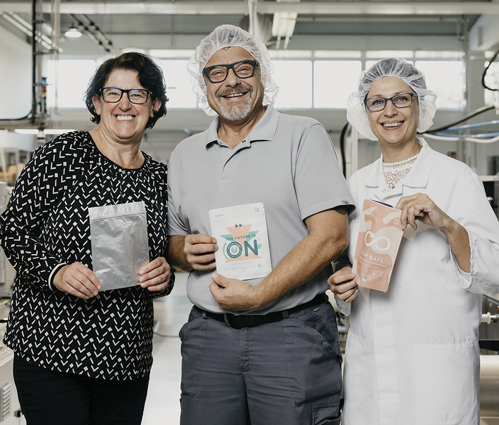 Drei Mitarbeiter die einen Beutel in der Hand halten